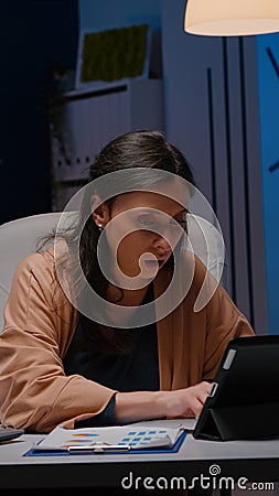 Workaholic focused businesswoman analysing financial graphics on tablet Stock Photo