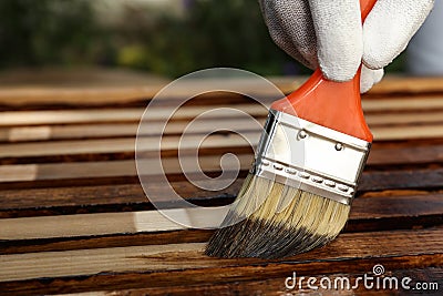 Worker applying wood stain onto planks, closeup. Space for text Stock Photo