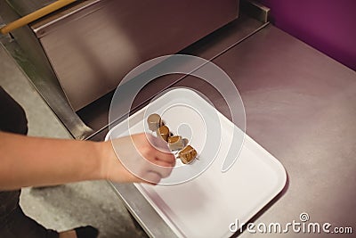 Worker arranging chocolate coated marshmallows on tray Stock Photo