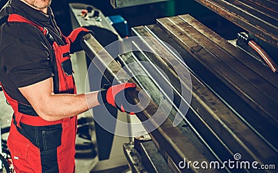 Worker Arranging Metal Square Tubes in Workshop Stock Photo