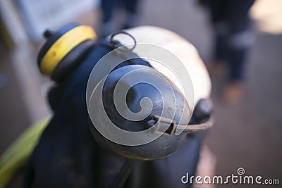 Worker attached ears muffs onto white helmet head as noise safety protection Stock Photo