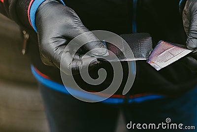 Worker with black rubber gloves in a workshop opening radial tire patch Stock Photo