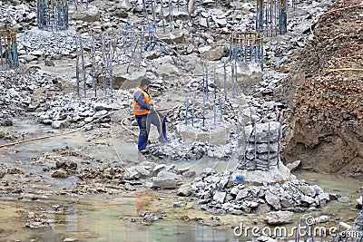 Worker breaking round piles with jackhammer Editorial Stock Photo