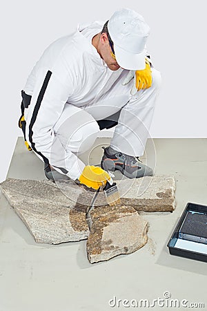 Worker brush primer grout of stones Stock Photo