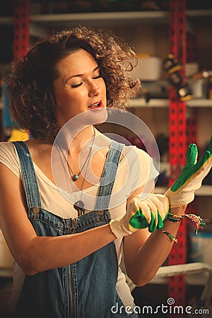 Worker of a car repair shop dressing protective gloves and sings Stock Photo