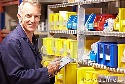 Worker Checking Stock Levels In Store Room Stock Photo