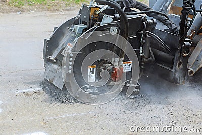 Worker checks the progress of the Milling of asphalt for road reconstruction accessory for skid steer Stock Photo