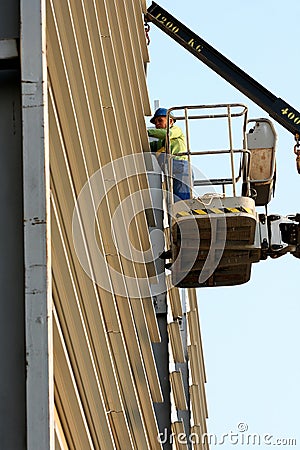 Worker on cherry picker in construction site Editorial Stock Photo