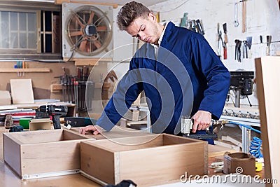 Worker chiseling plank at workshop Stock Photo