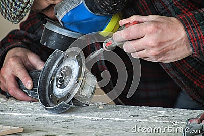 Master clamps protective casing in an angle grinder Stock Photo