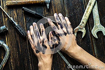 Worker class person dirty dark hands on the wooden table with tools equipment f Stock Photo