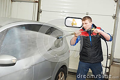 Worker cleaning car with pressured water Stock Photo