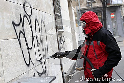 Worker cleaning graffiti Editorial Stock Photo