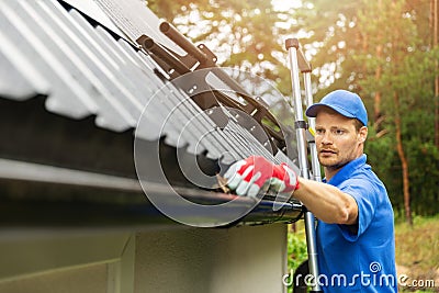 Worker cleaning house gutter Stock Photo