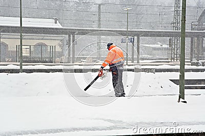 Worker is cleaning the platform of a train station Stock Photo