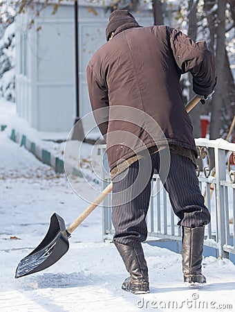 Worker cleans snow shovel in the nature Editorial Stock Photo