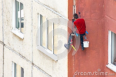 Worker Climber Hanging On Ropes on a High-Rise Building Facade and Sealing Joints. Maintenance of Joints between Precast Concrete Editorial Stock Photo