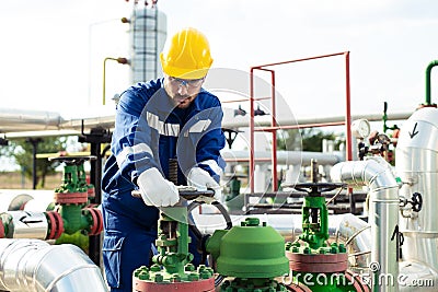 Worker closes the valve on the oil pipeline Stock Photo