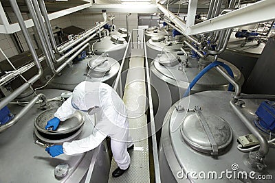 Worker closing industrial process tank in plant Stock Photo