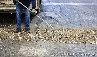 worker committed to the repair of a large pit road Stock Photo