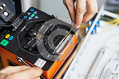 Worker comunicate fiber optic cable at opto box. installing new network equipment Stock Photo