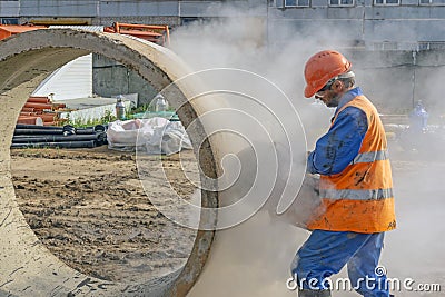 Builder in orange uniform with a concrete cutter Stock Photo