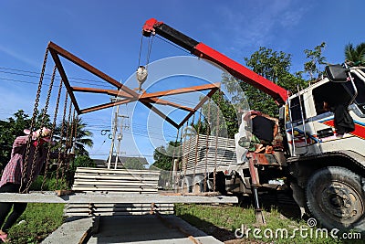 Worker controls of lifting crane for transporting concrete slabs Editorial Stock Photo