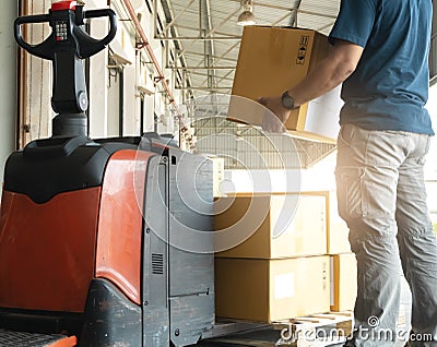 Worker courier lifting shipments boxes at the warehouse. Stock Photo