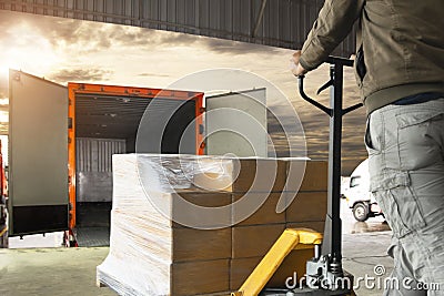 Worker courier unloading cargo pallet shipment goods into a truck Stock Photo