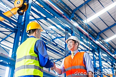 Worker and customer having agreement in factory Stock Photo