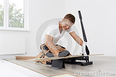 Worker cut wooden batten for laminate floor, floating wood tile Stock Photo