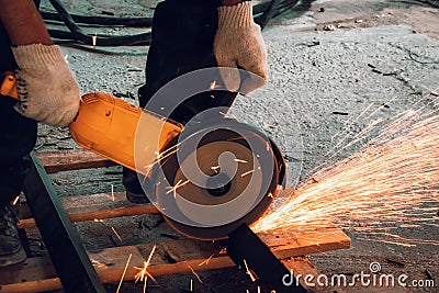Worker Cuts Metal with Grinder Circular Blade on Construction Site, close up Stock Photo