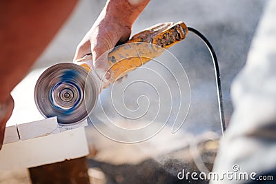 Worker cutting decorative stone used for facades in construction site Stock Photo