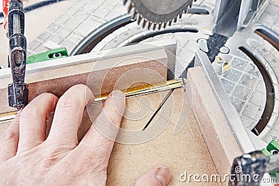 Worker cutting golden moulding on miter saw closeup Stock Photo