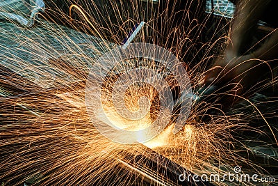 Worker cutting metal with grinder. Sparks while grinding iron Stock Photo