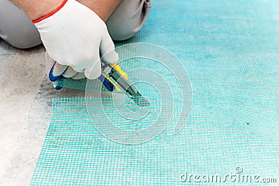 A worker is cutting a fiberglass mesh Stock Photo