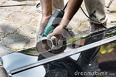 Worker cutting roof polycarbonate sheet with cutter tool Stock Photo