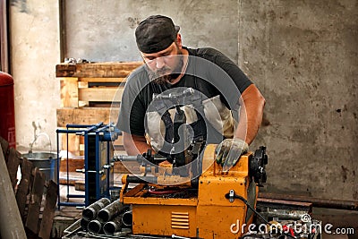 Worker cutting steel pipe with machine for threading Stock Photo