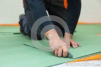 Worker cutting underlayment Stock Photo
