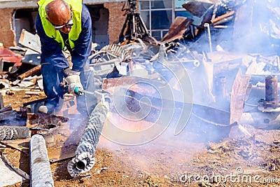 Worker is cutting scrap metal with acetylene torch Editorial Stock Photo