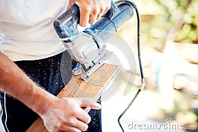 Worker cutting wood parquet using circular saw during home improvement works Stock Photo