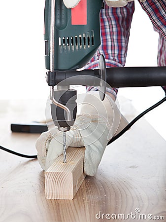 Worker drilling a hole in the wood Stock Photo