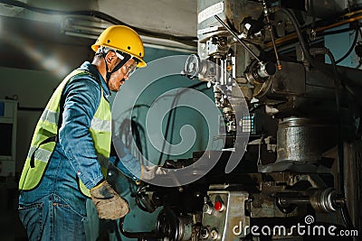 Worker Drilling machine hole metal flat steel plate and selective focus with bench drill in the factory Stock Photo
