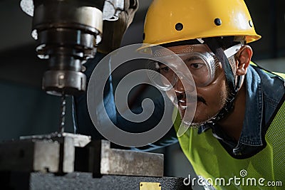 Worker Drilling machine hole metal flat steel plate and selective focus with bench drill in the factory, Close- up on the face Stock Photo