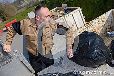 Worker dumping rubbish bags Stock Photo