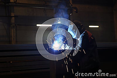 A worker electric welder cooks steel in a semi-automatic factory Stock Photo