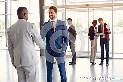 Worker at entrance shake hands with partner Stock Photo