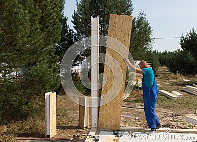 Worker erecting wall panels on a building site Stock Photo