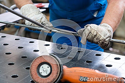 Worker in factory deburring workpieces of metal, close-up Stock Photo