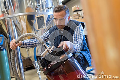 Worker filling tank in factory Stock Photo